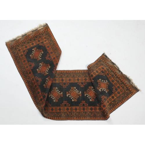 902 - Pakistani woollen runner, with a black field and terracotta hooked lozenge medallions, within a patt... 