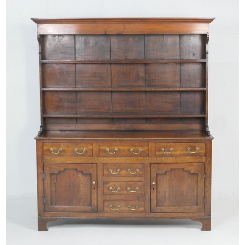 922 - George III oak dresser and plate rack, circa 1800-20, the boarded rack with three shelves over an en... 