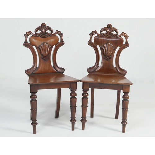 927 - Pair of Victorian mahogany hall chairs, circa 1860, carved backs centred with a scallop shell, over ... 