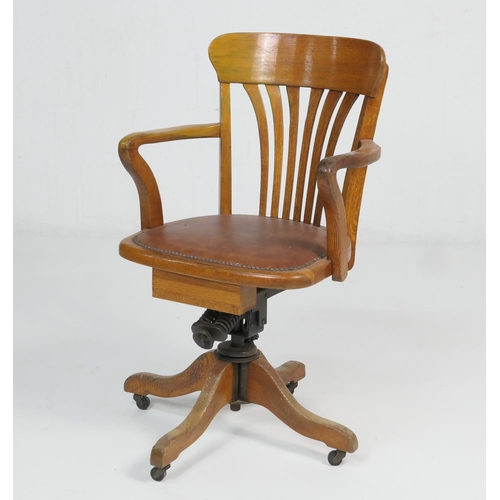 960 - George V oak swivel office chair, bowed back with open arms and rexine pad seat, over swivel mechani... 