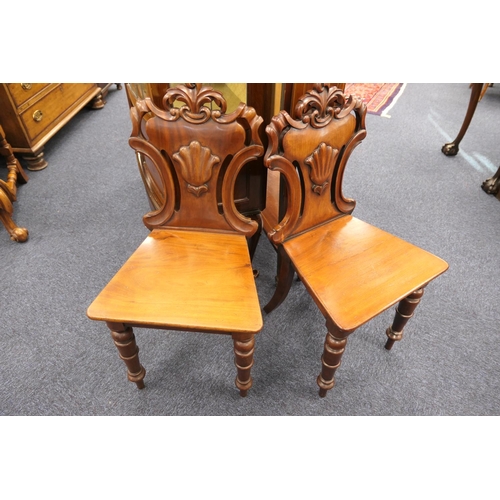 927 - Pair of Victorian mahogany hall chairs, circa 1860, carved backs centred with a scallop shell, over ... 