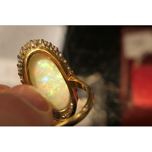 394 - Opal and diamond cluster ring, centred with a cabochon opal, 25mm x 10mm, depth approx. 13mm, in an ... 