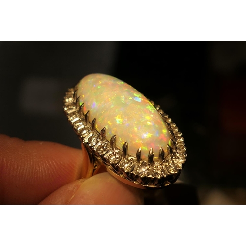 394 - Opal and diamond cluster ring, centred with a cabochon opal, 25mm x 10mm, depth approx. 13mm, in an ... 