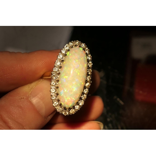 394 - Opal and diamond cluster ring, centred with a cabochon opal, 25mm x 10mm, depth approx. 13mm, in an ... 