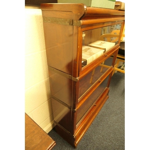 957 - Two Globe Wernicke mahogany three section bookcases, each with up and over glazed doors, on an ogee ... 