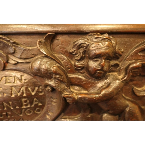 908 - Carved oak settle, the back centred with a dated carved oak panel with cherubs supporting an inscrib... 