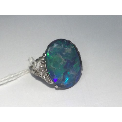 338 - Black opal and diamond ring, having a cabochon opal doublet of approx. 20mm x 16mm, the shoulders se... 