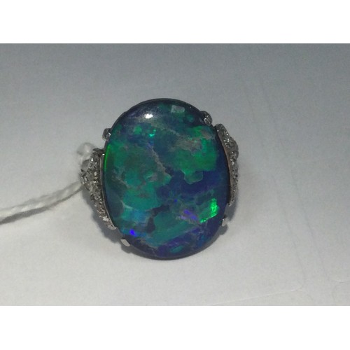 338 - Black opal and diamond ring, having a cabochon opal doublet of approx. 20mm x 16mm, the shoulders se... 