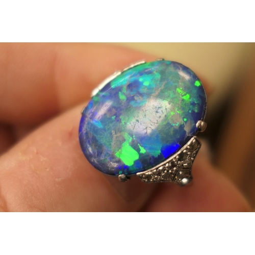 338 - Black opal and diamond ring, having a cabochon opal doublet of approx. 20mm x 16mm, the shoulders se... 