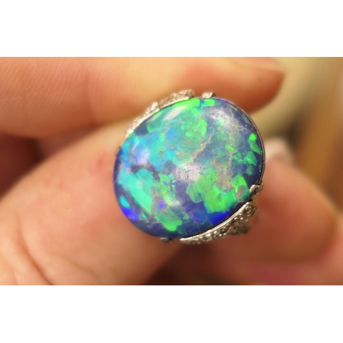 338 - Black opal and diamond ring, having a cabochon opal doublet of approx. 20mm x 16mm, the shoulders se... 