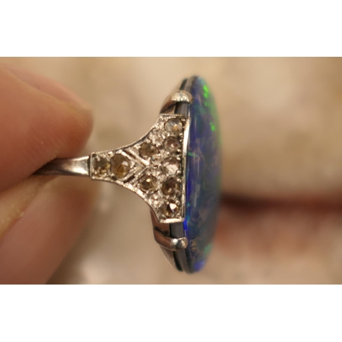 338 - Black opal and diamond ring, having a cabochon opal doublet of approx. 20mm x 16mm, the shoulders se... 