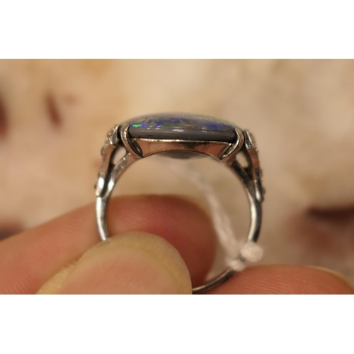 338 - Black opal and diamond ring, having a cabochon opal doublet of approx. 20mm x 16mm, the shoulders se... 