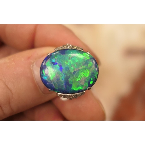 338 - Black opal and diamond ring, having a cabochon opal doublet of approx. 20mm x 16mm, the shoulders se... 