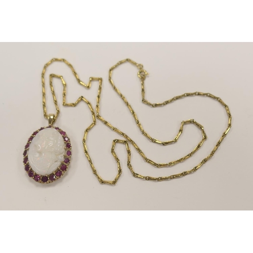 377 - Carved opal cameo pendant necklace, the opal bordered with round cut rubies set within 9ct gold with... 