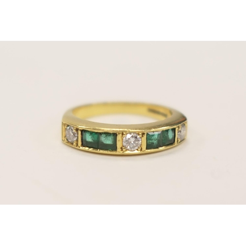 406 - Emerald and diamond half eternity ring in 18ct gold, channel set with three round cut diamonds, each... 