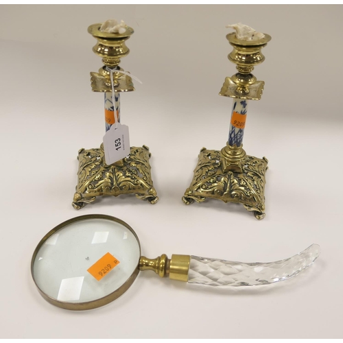 153 - Pair of Victorian cast brass and china column candlesticks; also a crystal handled magnifying glass