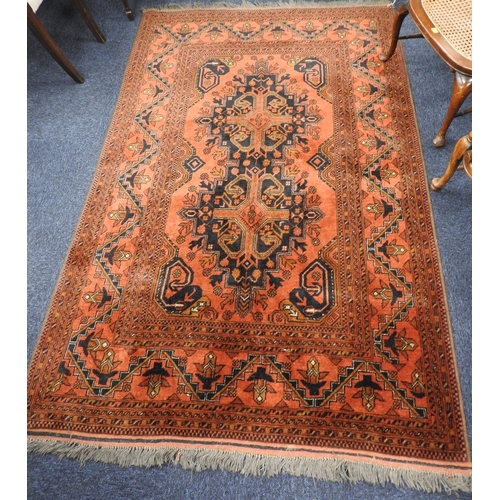 516 - Afghan madder ground woollen rug, 200cm x 130cm