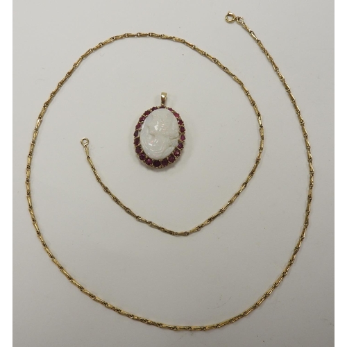 262 - Carved opal cameo pendant necklace, the opal bordered with round cut rubies set within 9ct gold with... 