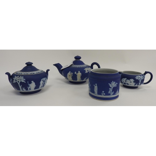 114 - Wedgwood dark blue jasper teapot, with a lidded sugar basin, a milk jug and an un-named jar (4)