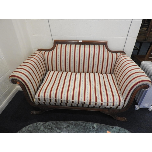 605 - Regency style mahogany framed two seater settee in red and cream striped fabric, raised on paw feet,... 