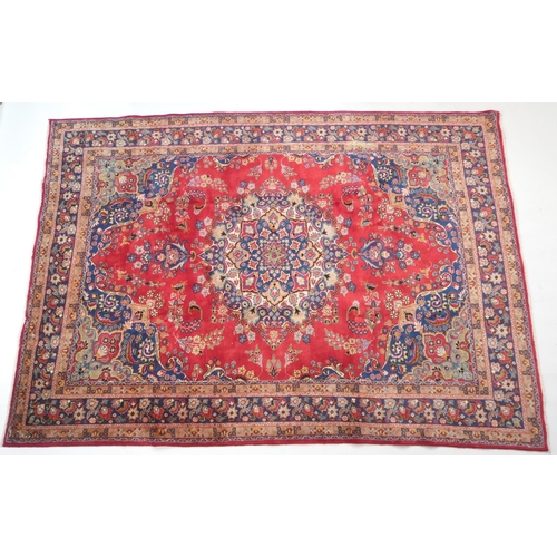 630 - Tabriz red ground woollen carpet, centred with a blue, red and fawn pendant medallion bordered with ... 