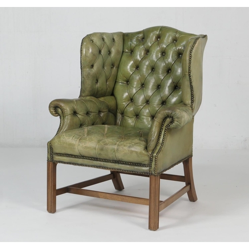 Deep buttoned green leather armchair in the Georgian style, raised on ...