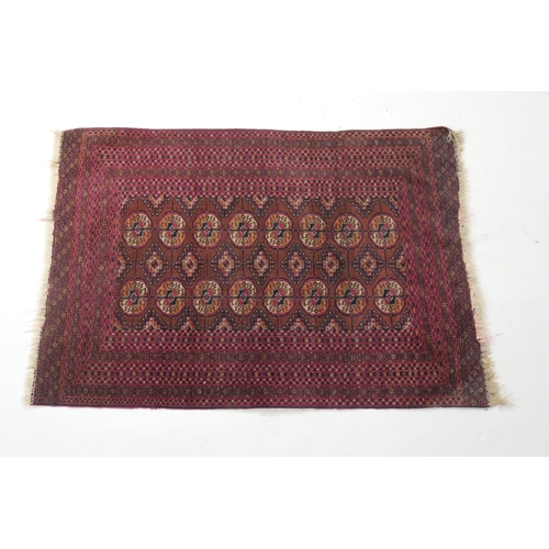 690 - Tekke Bokhara madder ground woollen rug, with two rows of guls and multi guard stripe border, size a... 