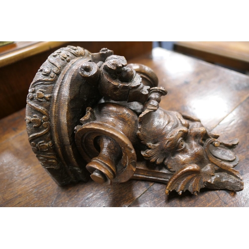 507 - Late 17th Century carved oak bracket, carved with a grotesque mask and paper scroll, 22cm x 16.5cm