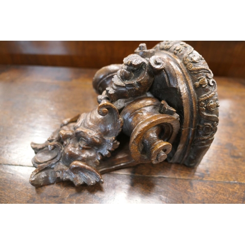 507 - Late 17th Century carved oak bracket, carved with a grotesque mask and paper scroll, 22cm x 16.5cm