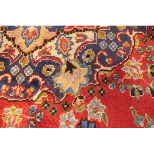 630 - Tabriz red ground woollen carpet, centred with a blue, red and fawn pendant medallion bordered with ... 