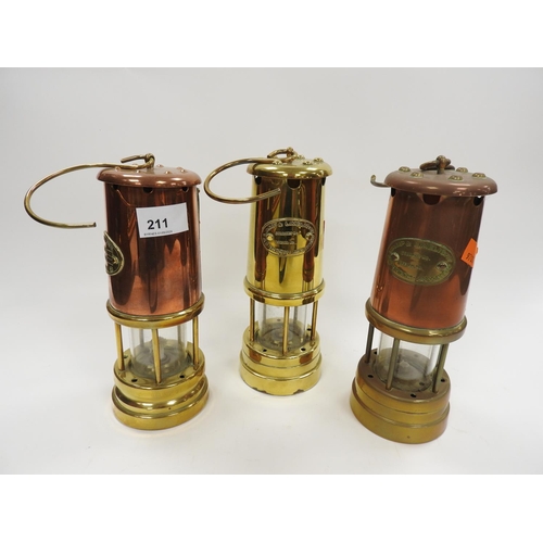 211 - Three reproduction brass miner's lamps