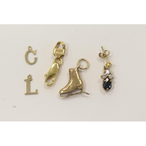 321 - 9ct gold ice-skate charm, two 9ct gold initial charms, 9ct gold lobster claw spring clip and a 9ct g... 