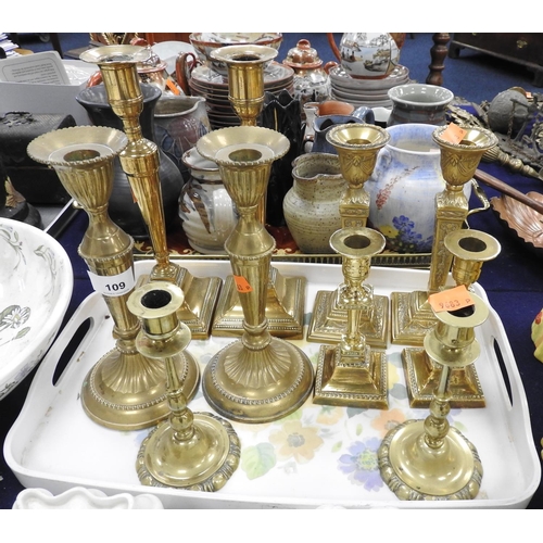 109 - Five pairs of decorative brass candlesticks