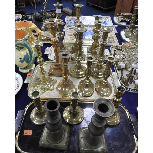 112 - George III brass petal footed candlestick, also Regency and later brass candlesticks (3 trays)