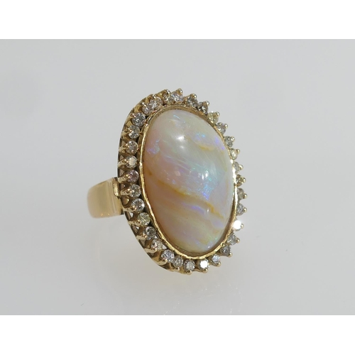 23 - Cabochon opal and diamond dress ring, the central opal of approx. 22mm x 19mm, bordered with a singl... 