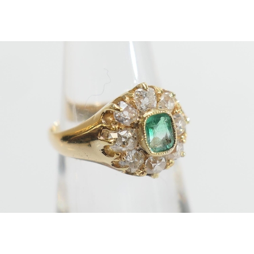 24 - Emerald and diamond cluster ring, the central emerald of approx. 0.25ct in a millegrain collet mount... 