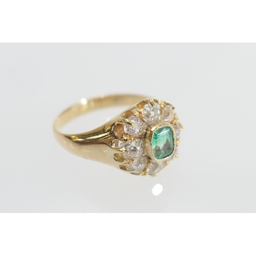 24 - Emerald and diamond cluster ring, the central emerald of approx. 0.25ct in a millegrain collet mount... 