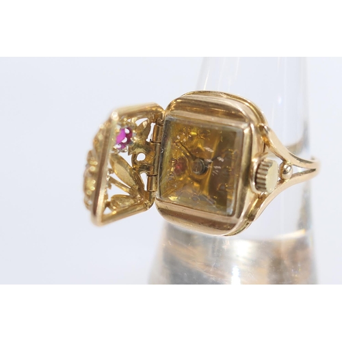 558 - 18ct yellow gold watch ring, the hinged cover worked with foliage and set with two round cut rubies,... 