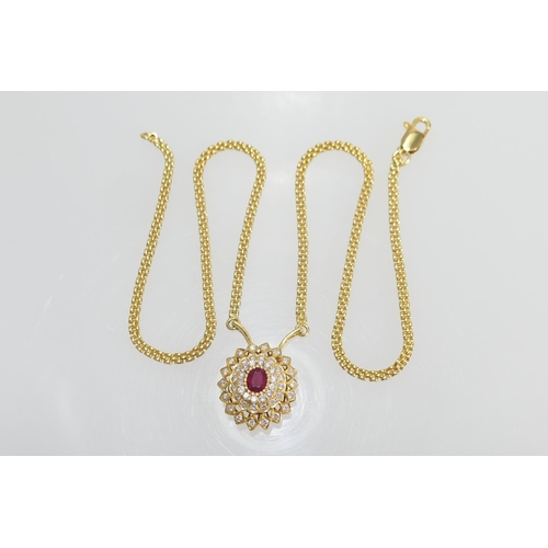 65 - Ruby and diamond cluster pendant necklace, centred with an oval ruby of approx. 1ct, bordered with t... 