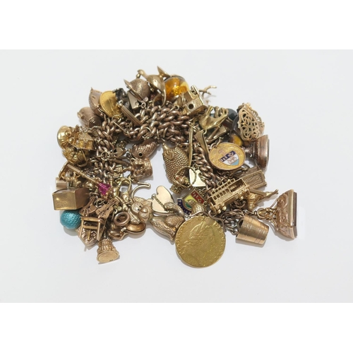 78 - 9ct gold charm bracelet, comprising approx. fifty charms including 1887 half sovereign; worn Georgia... 