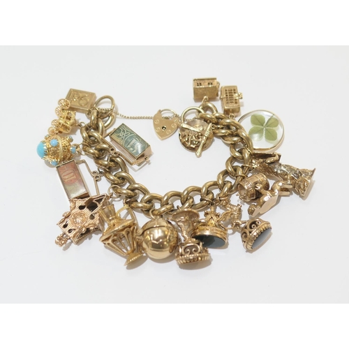 80 - 9ct gold charm bracelet, comprising two 18ct gold charms, thirteen 9ct gold charms, and two unmarked... 