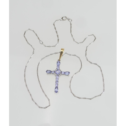 132 - Diamond and tanzanite set cross form pendant, the stones claw set in unmarked white gold with a yell... 