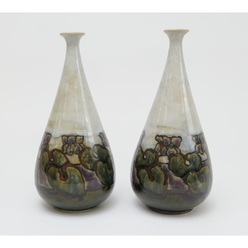 413 - Pair of Royal Doulton stoneware bottle vases, by Bessie Newbery, decorated around the base with rock... 