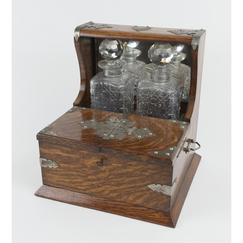 846 - Victorian oak tantalus, with nickel mounts, two moulded glass spirit decanters and opening covers to... 