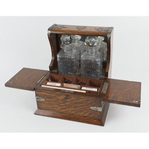 846 - Victorian oak tantalus, with nickel mounts, two moulded glass spirit decanters and opening covers to... 