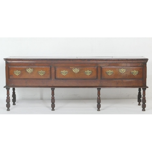 912 - Good Queen Anne oak low dresser, the top with moulded edge over three drawers with later brass fretw... 