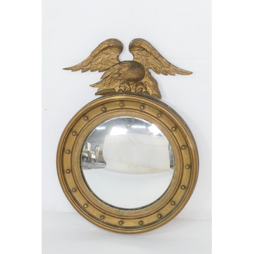 928 - Late Regency convex wall mirror, circa 1830, having a carved eagle surmount, cavetto and ball frame,... 