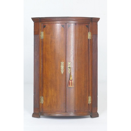 935 - George III oak and mahogany banded bowfront corner cupboard, opening to three shelves, height 100cm,... 