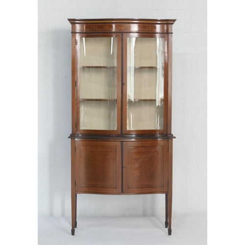 939 - Edwardian mahogany and inlaid serpentine front display cabinet, having a dentil inlaid cornice over ... 