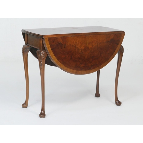 951 - Queen Anne Revival walnut drop leaf table, circa 1920-30, the crossbanded oval top with leaves, rais... 